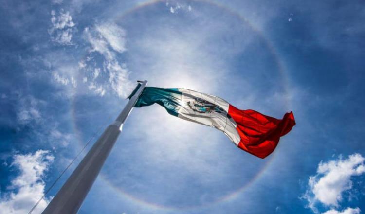 Imagen del Día: Hermosa bandera mexicana ondea bajo gigantesco halo solar