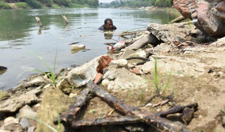 Imagen del Día: Busca fierros bajo el río para ganarse la vida