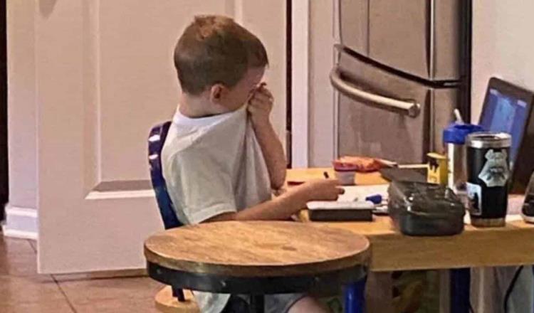 Niño llora frente a la computadora con frustración ante las clases virtuales