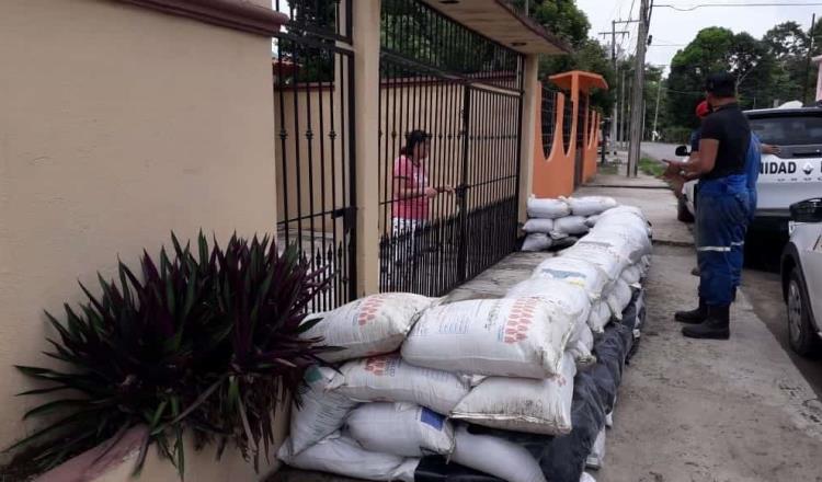 Cercan familias sus viviendas con costales de arena en Centro