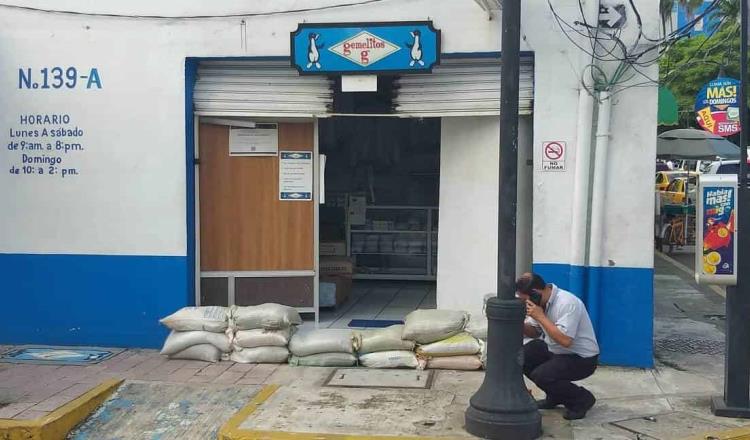 Comercios del centro de Villahermosa guardan mercancías y colocan costales, ante temor de que desborde el río Grijalva 