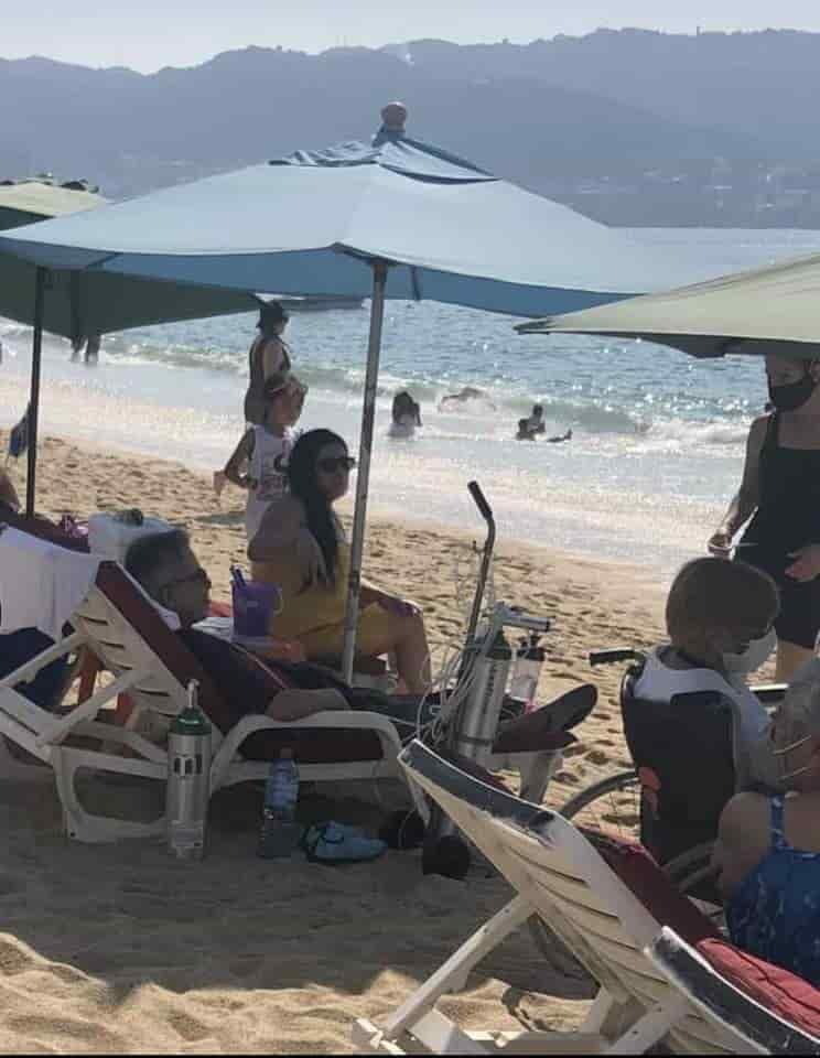 Hombre conectado a tanques de oxígeno y sin cubrebocas disfruta de la playa en Acapulco