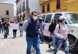 Atan manifestantes al secretario del ayuntamiento en Querétaro y lo exhiben por la calle