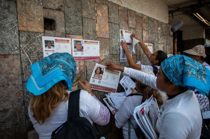 Madres de desaparecidos pegan fichas de búsqueda durante marcha en CDMX 